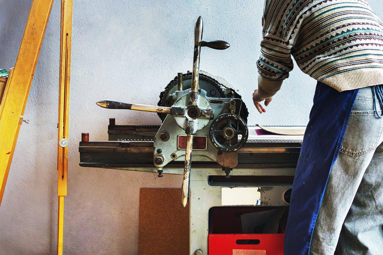 Atelier d’impression local avec équipement moderne en pleine création d'une œuvre sur presse mécanique.