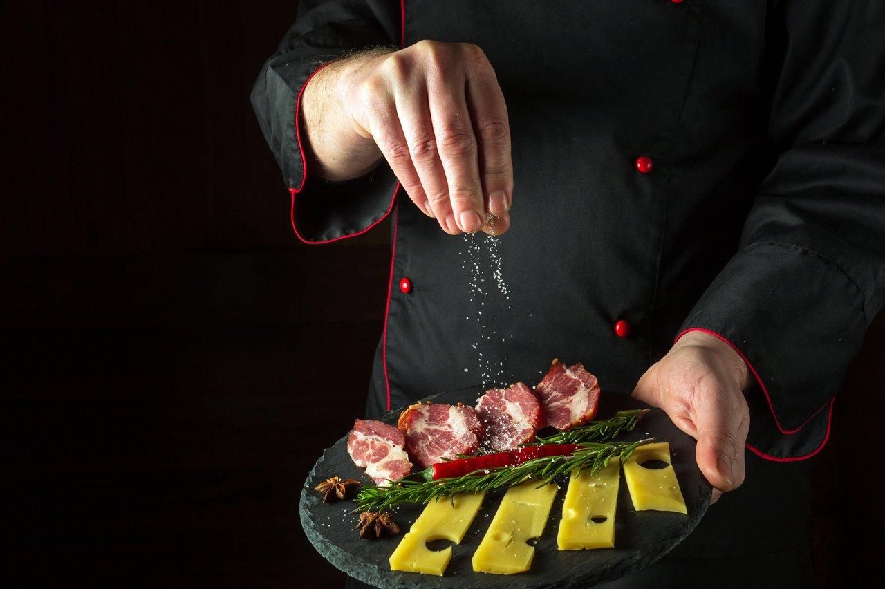 Flyer gastronomique au format A5 présenté en main, illustrant un gourmet menu flyer hand.