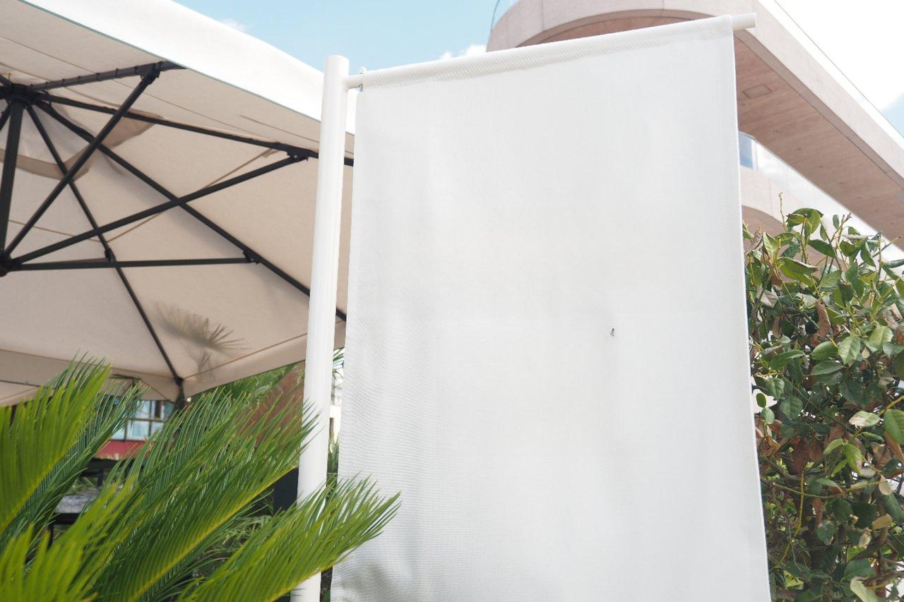Kakemono outdoor windproof installé sur terrasse de brasserie avec fixation robuste, résistant au vent et aux conditions extérieures.