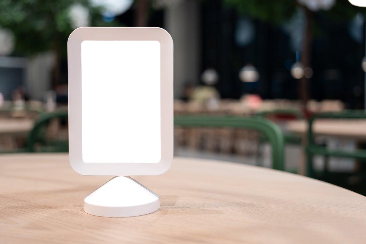 Un chevalet de table élégant en bois mettant en valeur une offre spéciale dans un restaurant moderne.