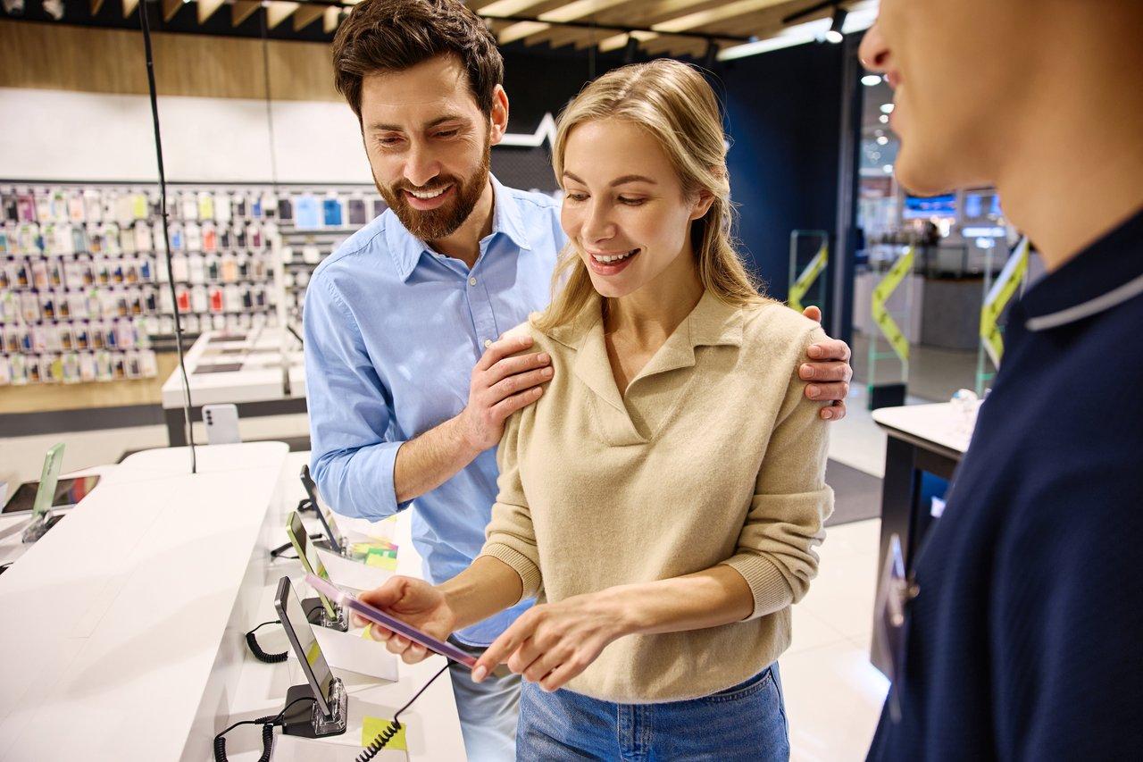 Une équipe retail réalise un relevé de la PLV en magasin avec une tablette pour optimiser la lisibilité.